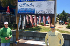 two men standing next to their day catch